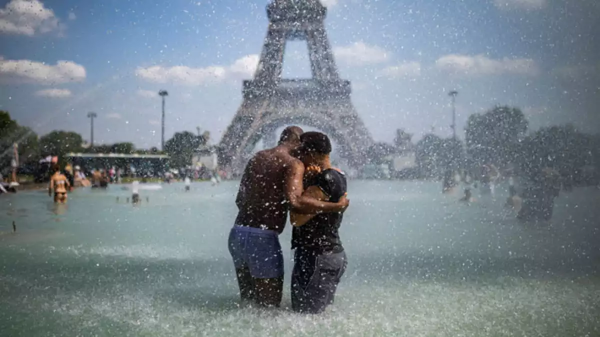 Gent banyant-se a les fonts davant de la Torre Eiffel de París per la calor extrema
